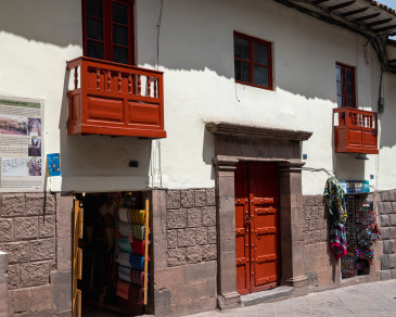 Cusco storefront with deep red door and balconies