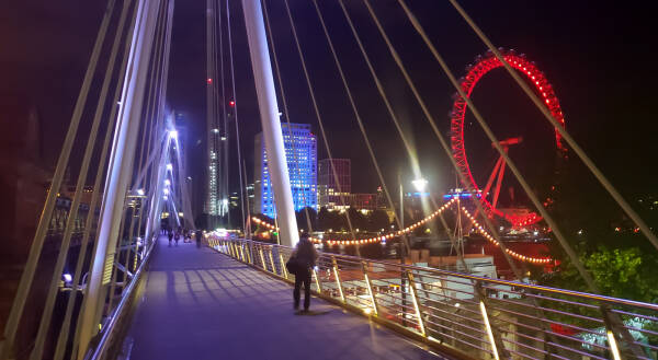 Crossing the Golden Jubilee Bridge in London at night.