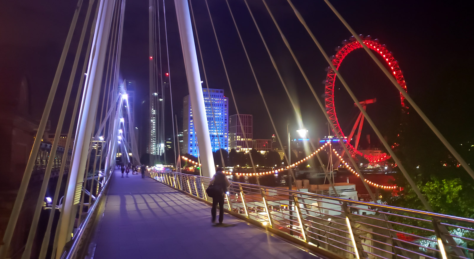 Crossing the Golden Jubilee Bridge in London at night.