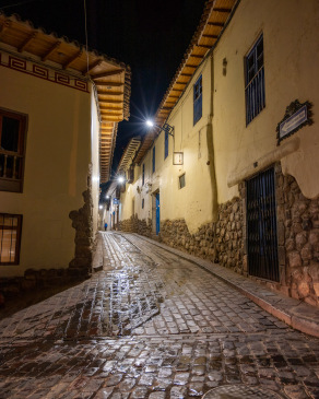 Streetlights shine on cobblestone streets in the San Blas district of Cusco