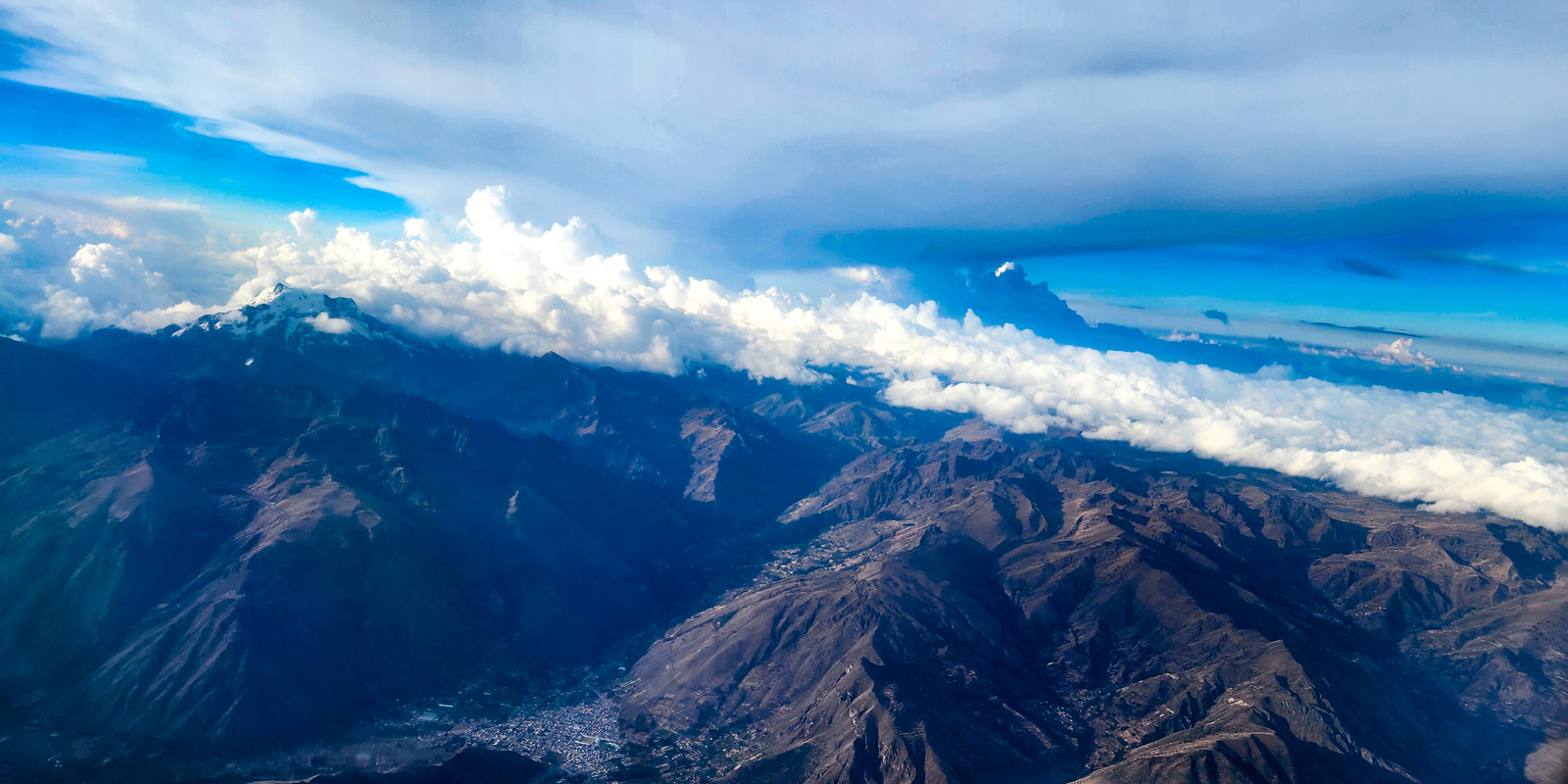 Dramatic blue view of the Andes mountains on a flight between Lima and Cusco
