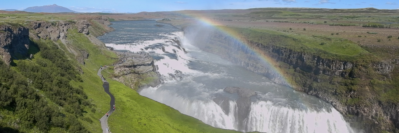 Panoramic view of the Gullfoss waterfall in Iceland including a rainbow.