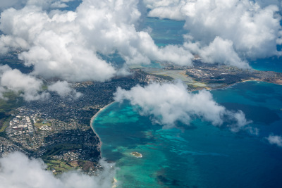 Turquoise seas and fluffy white clouds surround the island of Oahu from the window of my landing plane.