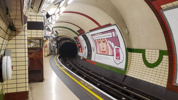 The tube of an immaculate London Underground station curves into the distance.