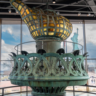 Lady Liberty is seen through a window outside the museum housing her old torch.