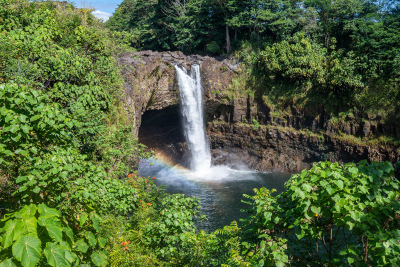 A rainbow shines in the morning sun at Rainbow Falls in Hilo, Hawaii