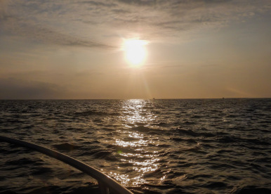 View of a golden sunset from the bow of a dive boat