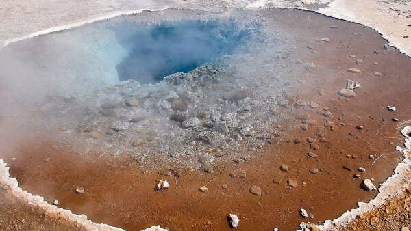 Steam emerges from the blue hole of a geothermal vent near Geysir in the Haukadalur valley of Iceland.