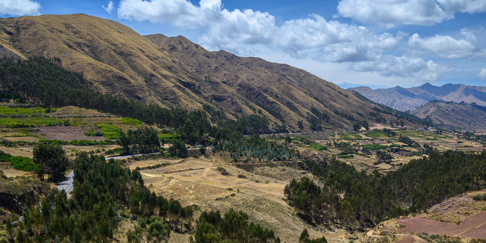 Mountains lined with ancient terraces recede into the distance in a view from Puka Pukara near Cusco.