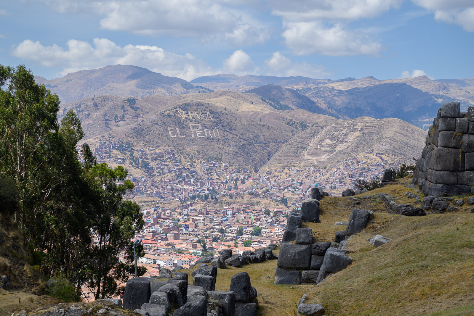 Sign carved into a Cusco hilltop seen from SacsayhuamÃ¡n