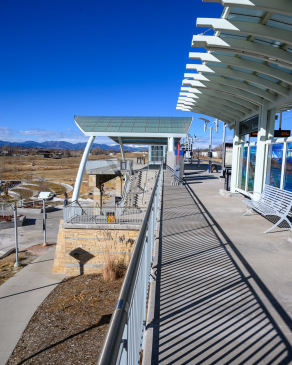 The lines and curves of Westminster Station near Denver, Colorado recede toward the Rocky Mountains in the distance.