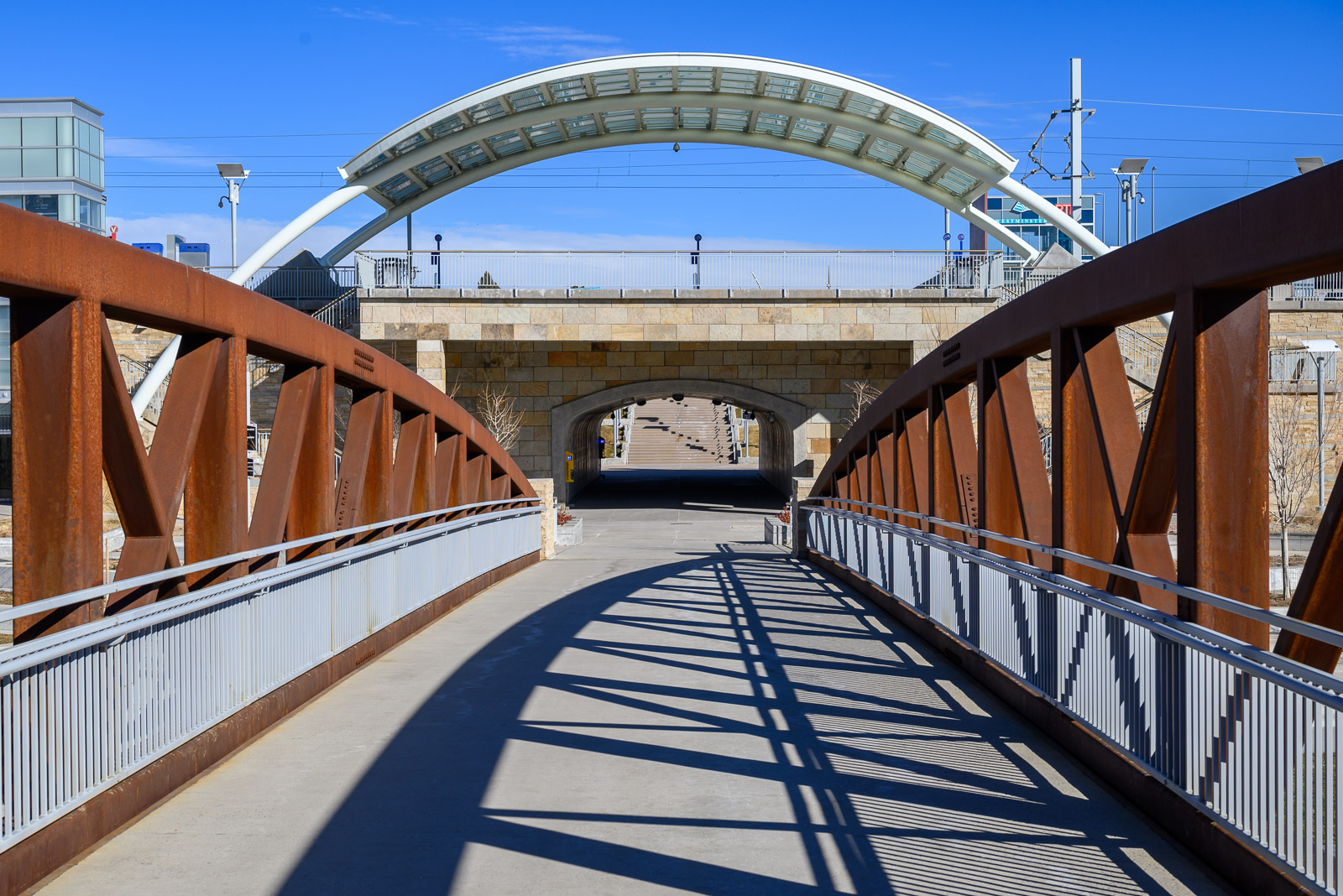 Curved bridge trusses cast strong shadows on the approach to Westminster Station near Denver, Colorado.