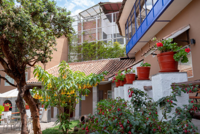 Red and yellow flowers fill the courtyard at Casa Andina San Blas