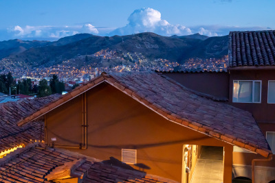 The lights of Cusco sparkle in the hills as the sun sets in Cusco