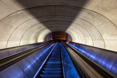 Four lights shine at the end of an escalator tunnel on the DC Metro.