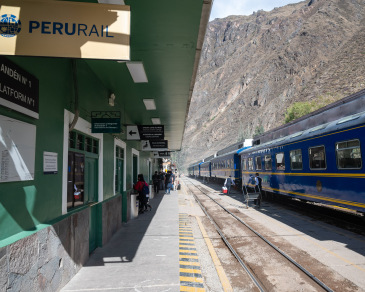 A blue train waits at Ollantaytambo station.