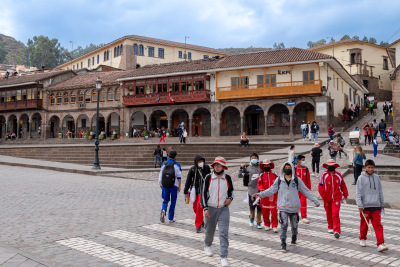 Students in red uniforms walk downhill towards the plaza in Cuzco