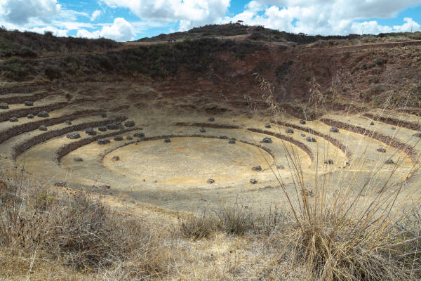 Dappled sunlight shines on a circle of Incan agricultural terraces in Peru.