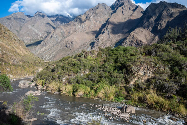 The Urubamba River flows between tall mountains  seen from the train to Machu Picchu.