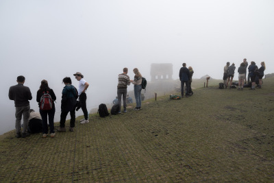 People wait for the fog to clear for a glimpse of Machu Picchu near House of the Guardians